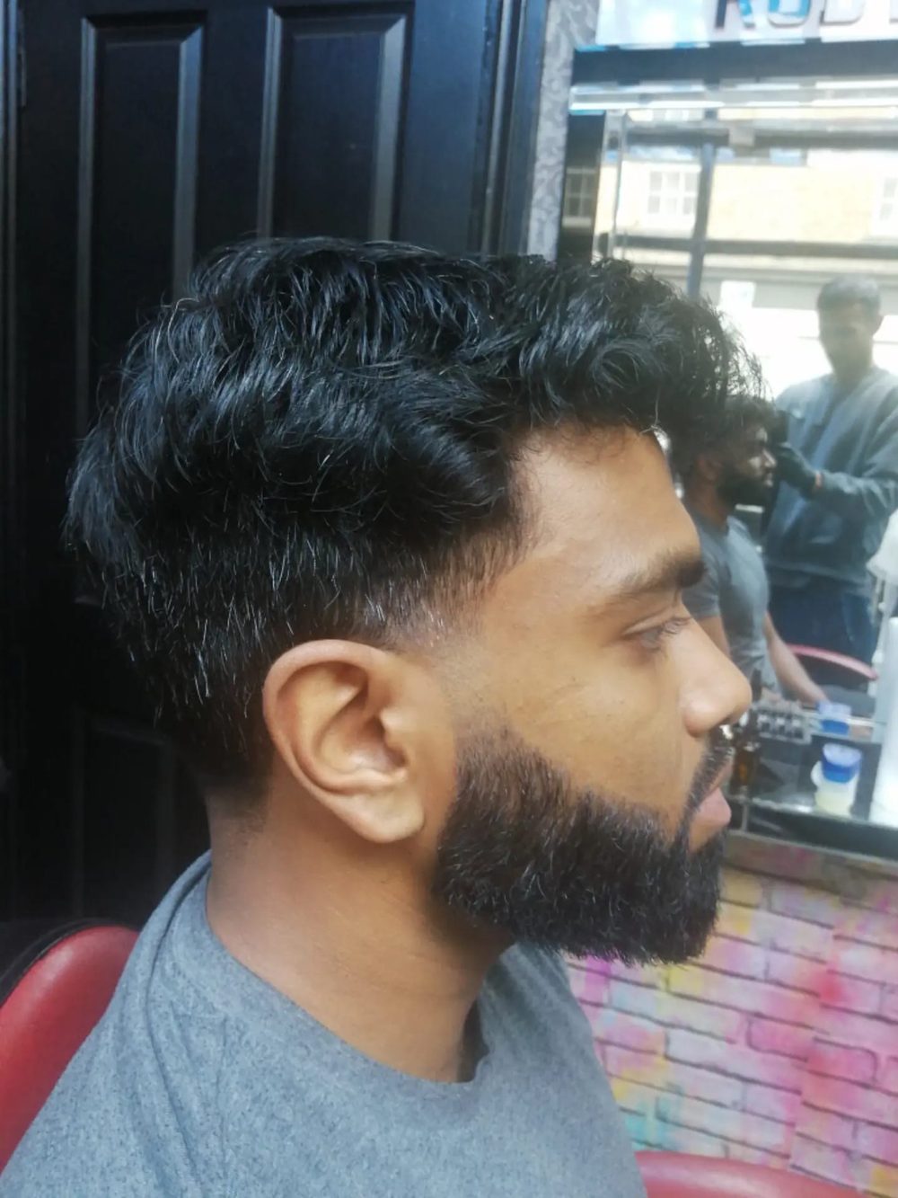A textured crop with a sculpted full beard, styled at Gentleman's Barber.