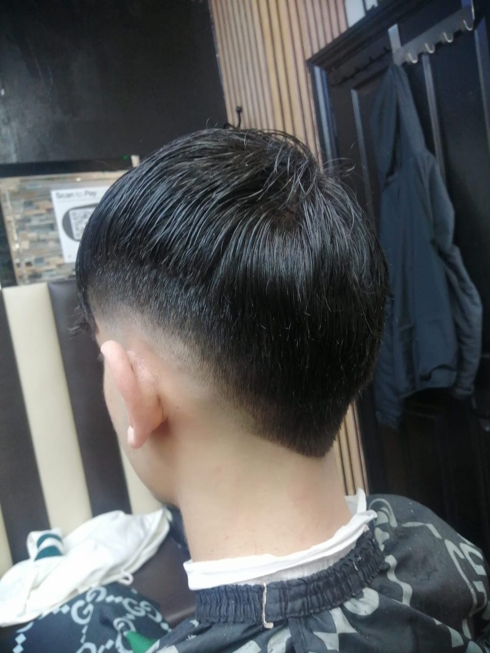 Back view of a clean low taper fade with a textured top, cut at Gentleman's Barber.